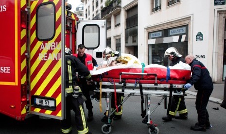 Petugas medik membawa korban yang terluka saat penembakan kantor majalah Charlie Hebdo di Paris, Prancis.