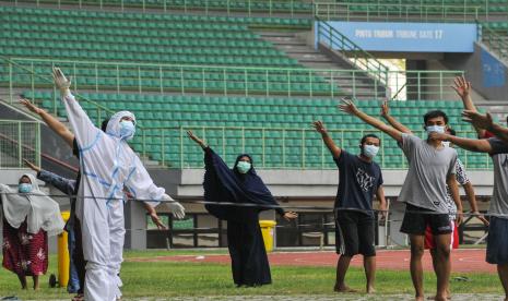 Petugas medis (kiri) memimpin senam pagi bersama pasien Covid-19.