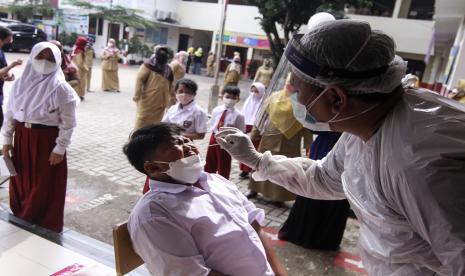 Petugas medis melakukan tes antigen kepada siswa di SDN Depok 1, Depok, Jawa Barat, Senin (18/10/2021). Pemerintah Kota Depok melakukan tes antigen COVID-19 secara acak bagi pelajar dan guru sejumlah sekolah untuk memastikan kesehatan siswa dan mencegah terjadinya klaster baru penyebaran COVID-19 di sekolah selama Pembelajaran Tatap Muka (PTM) Terbatas.