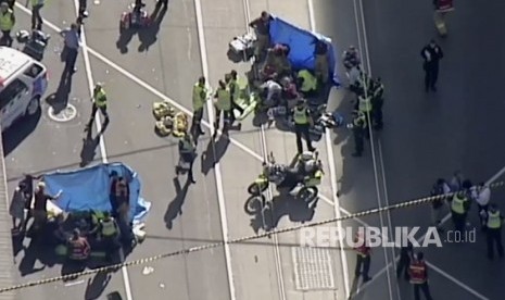 Petugas medis memberikan bantuan kepada korban yang tertabrak kendaraan di Melbourne, Australia. Kamis (21/12).  