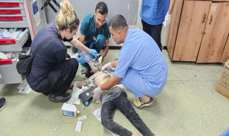 Petugas medis menangani korban anak yang diserang di Al-Muwaisi, Gaza.