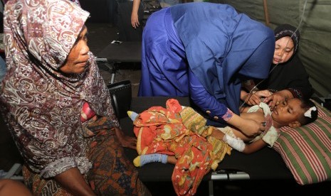 Petugas medis menangani seorang anak korban gempa di Rumah Sakit Umum Daerah (RSUD) Tgk Chik Ditiro Sigli di Pidie, Aceh, Rabu (7/12).