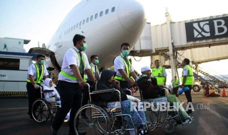 Petugas medis mendorong kursi roda jemaah haji yang sakit saat tiba di tanah air di Bandara Internasional Juanda Surabaya di Sidoarjo, Jawa Timur