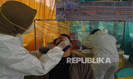 Petugas medis mengambil sampel lendir warga saat melakukan tes swab antigen. 