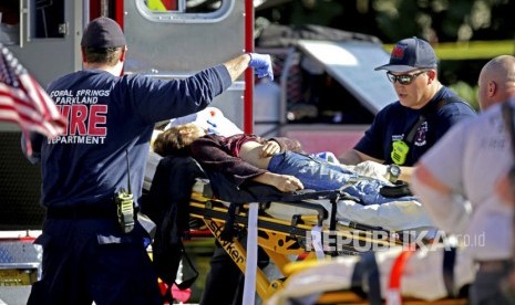 Petugas medis mengevakuasi korban penembakan di Marjory Stoneman Douglas High School di Parkland, Florida, Rabu (14/2). 