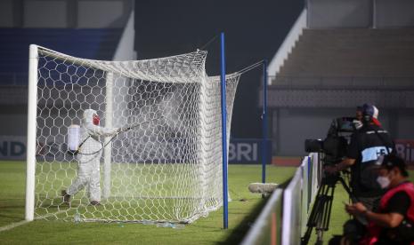 Petugas medis menyemprotkan cairan disinfektan ke gawang saat waktu istirahat dalam pertandingan BRI Liga 1.