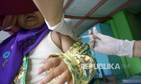 Petugas medis menyuntikkan vaksin MR (measles and rubella) kapada siswa TK di Tulungagung, Jawa Timur, Rabu (9/8). 