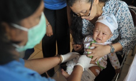 Petugas medis menyuntikkan vaksin polio ke seorang balita saat dimulainya Introduksi Vaksin Polio Suntik (IPV) 2016 di Gianyar, Bali, Jumat (22/7).  