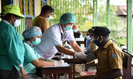 Petugas medis Puskesmas Agats melakukan pemeriksaan kesehatan warga yang akan menerima suntikan vaksin COVID-19 di Ewer, Asmat, Papua, Jumat (2/7/2021). Pemerintah Kabupaten Asmat gencar melaksanakan vaksinasi COVID-19 untuk masyarakat termasuk jemput bola dengan mengerahkan tenaga kesehatan ke kampung-kampung.