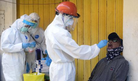 Petugas medis Puskesmas Kecamatan Pasar Minggu mengambil sampel lendir warga saat tes Swab di Terminal Pasar Minggu, Jakarta.