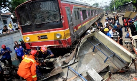 Petugas melakukan evakuasi bangkai Bus Metromini pascatabrakan dengan KRL di Kawasan Stasiun Angke, Jakarta Barat, Ahad (6/12).  (Republika/WIhdan)