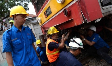 Petugas melakukan evakuasi bangkai Bus Metromini pascatabrakan dengan KRL di Kawasan Stasiun Angke, Jakarta Barat, Ahad (6/12).  (Republika/WIhdan)