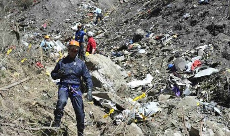 Petugas melakukan investigasi di lokasi jatuhnya pesawat Airbus A320 maskapai Germanwings di Seyne-les-Alpes, pegunungan Alpen, Prancis, Kamis (26/3).  