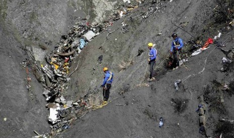 Petugas melakukan investigasi di lokasi jatuhnya pesawat Airbus A320 maskapai Germanwings di Seyne-les-Alpes, pegunungan Alpen, Prancis, Kamis (26/3).  