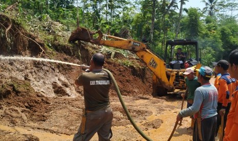 Petugas melakukan pembersihan material longsor di Jalan Cikeusal-Warung Legok, Desa Pasiralam, Kecamatan Mangunreja, Kabupaten Tasikmalaya, Kamis (23/1). Akses jalan kabupaten itu masih belum bisa dilalui kendaraan. BPBD Kabupaten Tasikmalaya menargetkan, setidaknya jalan bisa kembali dibuka untuk umum pada Jumat (24/1). 