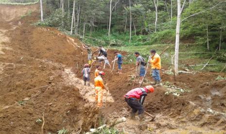 Petugas melakukan pembersihan material longsor yang menutup akses jalan di Desa Nangtang, Kecamatan Cigalontang, Kabupaten Tasikmalaya, Rabu (16/12). Longsor di kawasan itu menyebabkan akses jalan alterternatif Cigalontang-Salawu terputus total. 