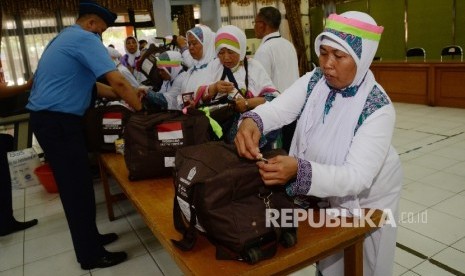 Petugas melakukan pemeriksaan calon jamaah haji kloter 5 asal Kuningan di Asrama Haji Embarkasi Jakarta Bekasi, Kota Bekasi, Jabar, Kamis (11/8).  (Republika/ Yasin Habibi)