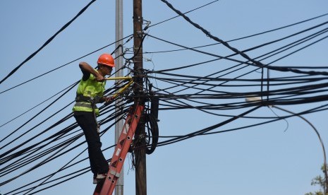 Petugas melakukan pemeriksaan jaringan listrik ilegal pada tiang milik PLN sebelum dilakukan pembokaran di Kawasan Tugu Tani, Jakarta, Jumat (26/2). 