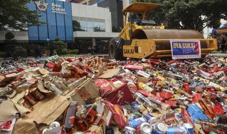 Petugas melakukan pemusnahan barang bukti minuman keras ilegal hasil penindakan barang milik negara dengan menggunakan alat berat di Kantor Pelayanan Utama Bea dan Cukai Tipe B Batam, Kepulauan Riau, Rabu (5/10/2022). Bea Cukai Batam memusnahkan 46 ribu batang rokok serta minuman keras ilegal dengan nilai barang sebesar Rp9,9 miliar dengan potensi kerugian negara sebesar Rp3,1 miliar. 