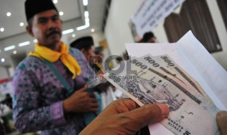 Forum KBIH Tanggapi Wacana Uang Saku Jamaah Haji Dipangkas. Foto: Petugas melakukan pengecekan kembali Living Cost yang dibagikan kepada calon Jamaah Haji di Asrama Haji Pondok Gede, Jakarta, Rabu (26/8).   (Republika/Rakhmawaty La