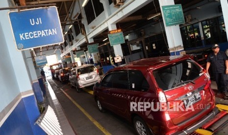   Petugas melakukan pengecekan saat uji uji kendaraan bermotor (KIR) Taksi berbasis aplikasi daring (online) di Pengelola Pengujian Kendaraan Bermotor, Pulo Gadung, Jakarta Timur, Senin (1/8).(Republika/Yasin Habibi)