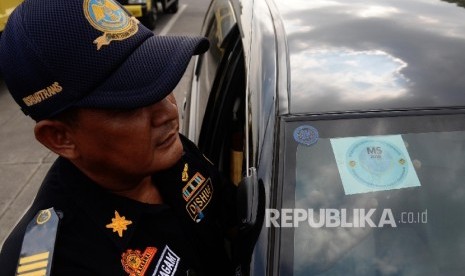 Petugas melakukan pengecekan saat uji uji kendaraan bermotor (KIR) Taksi berbasis aplikasi daring (online) di Pengelola Pengujian Kendaraan Bermotor, Pulo Gadung, Jakarta Timur, Senin (1/8). (Republika/Yasin Habibi)