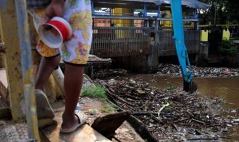 Petugas melakukan pengerukan sampah dipintu air Manggarai, Jakarta, Selasa (21/2).  (Republika/Edwin Dwi Putranto)