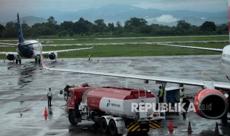 Petugas melakukan pengisian bahan bakar avtur milik pertamina pada salah satu pesawat perusahaan penerbangan di Apron Bandara Internasional Sultan Hasanuddin, Sulsel, Selasa(21/3). 