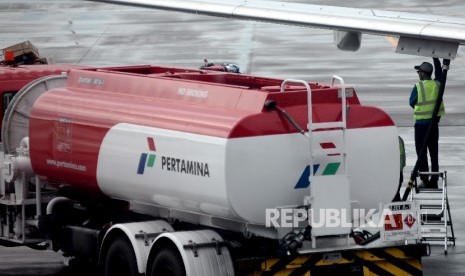 Petugas melakukan pengisian bahan bakar avtur milik pertamina pada salah satu pesawat perusahaan penerbangan di bandara. ilustrasi