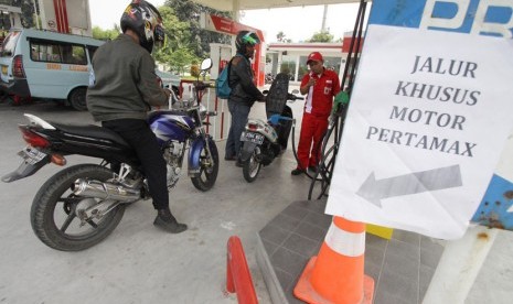 Petugas melakukan pengisian bahan bakar Pertamax di SPBU Kalideres, Jakarta Barat, Kamis (4/12).