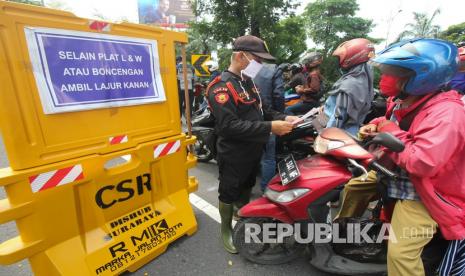 Petugas melakukan penyekatan di pos pemeriksaan Bundaran Waru, Surabaya, Jawa Timur, Senin (25/5/2020). Pada hari terakhir pelaksanaan PSBB tahap kedua Surabaya yang bertepatan dengan hari kedua Idul Fitri 1441 H, petugas gabungan meminta sejumlah pengendara yang akan masuk Kota Surabaya untuk berputar balik disebabkan tidak mengenakan masker, melebihi jumlah 50 persen kapasitas penumpang kendaraan bermotor dan tidak mempunyai urusan penting atau mendesak.