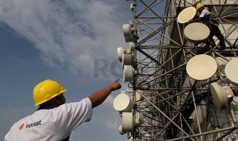 Petugas melakukan perawatan berkala pemancar Indosat, Jakarta, Senin (23/6).