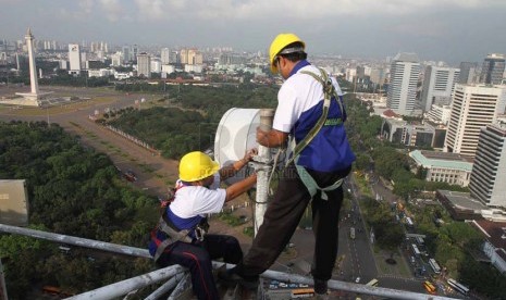 Petugas melakukan perawatan berkala pemancar Indosat, Jakarta, Senin (23/6).