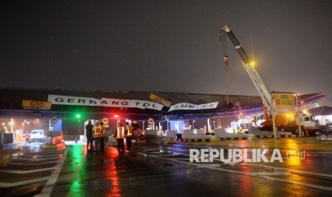 Petugas melakukan perbaikan atap gerbang Tol Cikunir 2 yang ambruk akibat hujan badai di Bekasi, Ahad (14/2).Republika/ Wihdan Hidayat