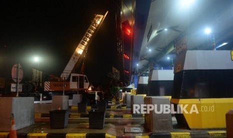 Petugas melakukan perbaikan atap gerbang Tol Cikunir 2 yang ambruk akibat hujan badai di Bekasi, Ahad (14/2) malam. (Republika/Yasin Habibi)