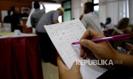 Petugas melakukan proses rekapitulasi penghitungan surat suara Pilkada DKI Jakarta tingkat kecamatan di Kantor Kecamatan Pasar Minggu, Jakarta, Kamis (16/2).