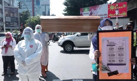 Petugas melakukan sosialiasi bahaya Covid-19 dengan membawa peti jenazah di Cilandak, Jakarta Selatan.