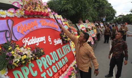 Petugas melakukan sterilisasi karangan bunga untuk pernikahan putri Presiden Joko Widodo, Kahiyang Ayu (kanan) dengan Bobby Nasution (kiri) di Gedung Graha Saba, Solo, Jawa Tengah, Senin (6/11). 