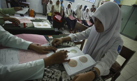 Petugas melakukan tes kesehatan pelajar saat proses penerimaan sisiwa didik baru jalur reguler di Sekolah Menengah Kejuruan (SMK) Negeri 6 Yogyakarta, Rabu (1/7). 