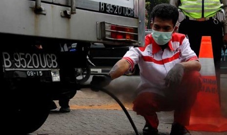 Petugas melakukan uji asap dari kendaraan pribadi saat pelaksanaan uji emisi gratis di kawasan Tugu Proklamasi, Jakarta.