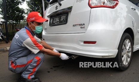  Petugas melakukan uji emisi gas buang pada kendaraan roda empat yang melintas di Jalan Pemuda, Jakarta Timur, Selasa (26/4). (Republika / Yasin Habibi)