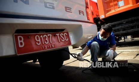 Petugas melakukan uji emisi kendaraan dinas oprasional dan kendaraan pribadi karyawan Dinas Lingkungan Hidup DKI Jakarta, Rabu (29/3)