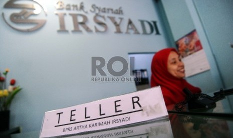 Petugas melanyani nasabah di kantor Bank Perkreditan Rakyat Syariah (BPRS) Irsyadi di Pondok Gede, Jawa Barat, Senin (22/6).