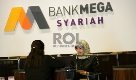 Petugas melayani nasabah di Bank Mega Syariah, Jakarta, Kamis (5/3).