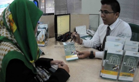  Petugas melayani nasabah di banking hall Bank Syariah Mandiri (BSM), Jakarta, Senin (3/8). 