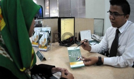 Petugas melayani nasabah di banking hall Bank Syariah Mandiri (BSM), Jakarta, Senin (3/8).