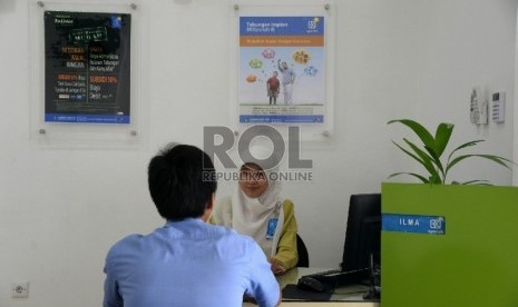 Petugas melayani nasabah di kantor BRI Syariah, Jakarta, Kamis (28/5).