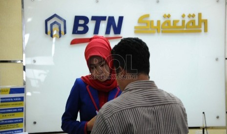 Petugas melayani nasabah di kantor cabang Bank BTN Syariah. 