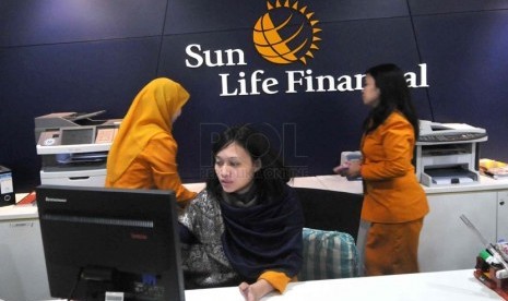 Petugas melayani nasabah di kantor layanan Sun Life Financial, Jakarta, Selasa ((18/3).