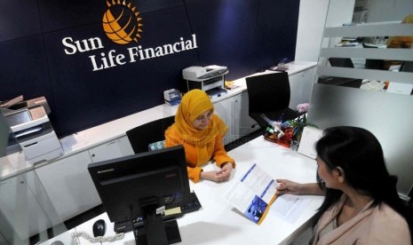 Petugas melayani nasabah di kantor layanan Sun Life Financial, Jakarta, Selasa ((18/3).